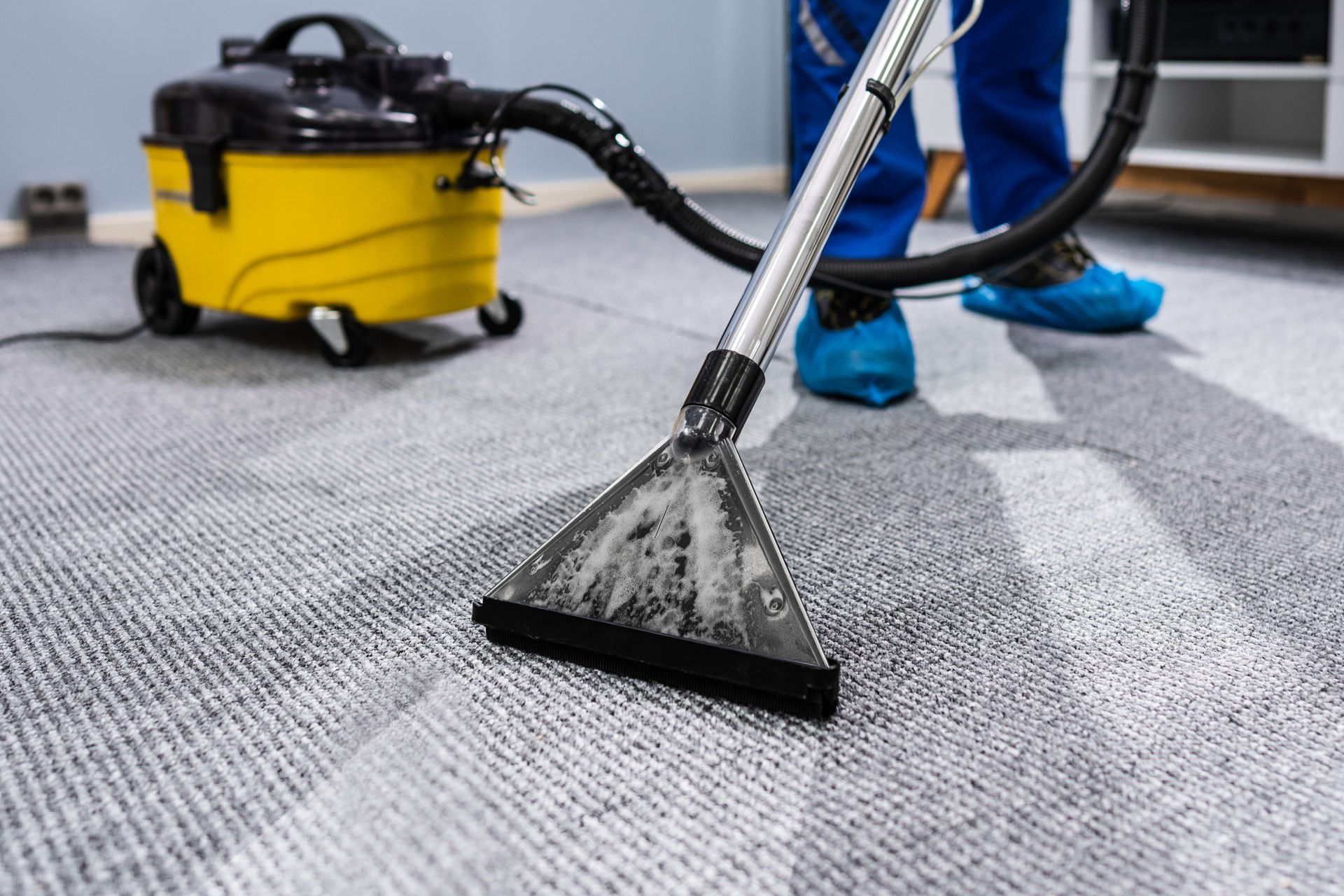 Person Cleaning Carpet With Vacuum Cleaner